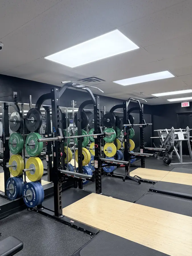 Squat racks with colored bumper plates and lifting platforms