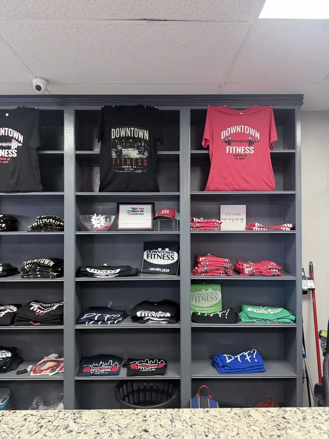 Downtown Fitness shirts and caps on the merch wall