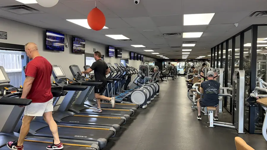 A member mid-stride on the treadmills in the cardio hall