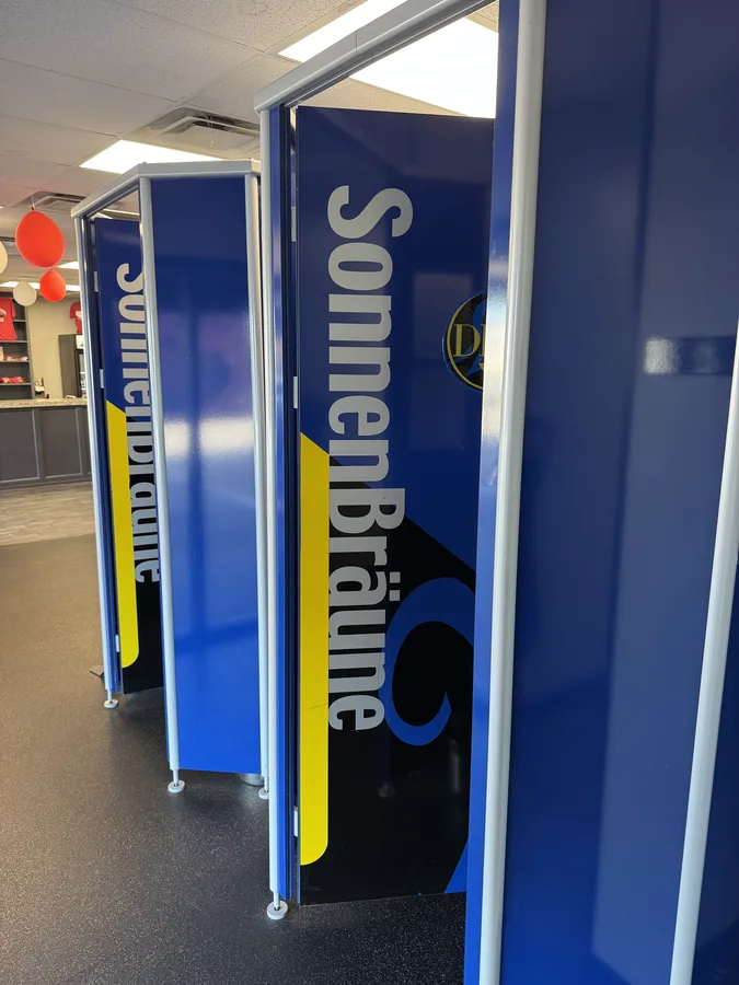 A row of stand-up SonnenBräune high-pressure tanning booths