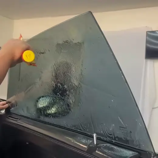 A squeegee pass across the door glass of a Dodge Charger