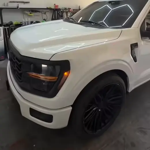 A tinted white 2026 Ford F-150 under the hexagon lights