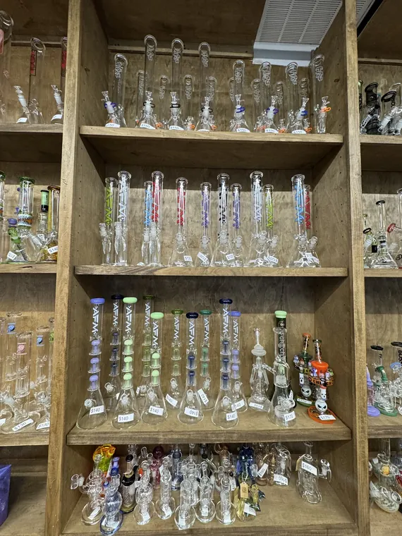 Tall glass water pipes on wooden shelves